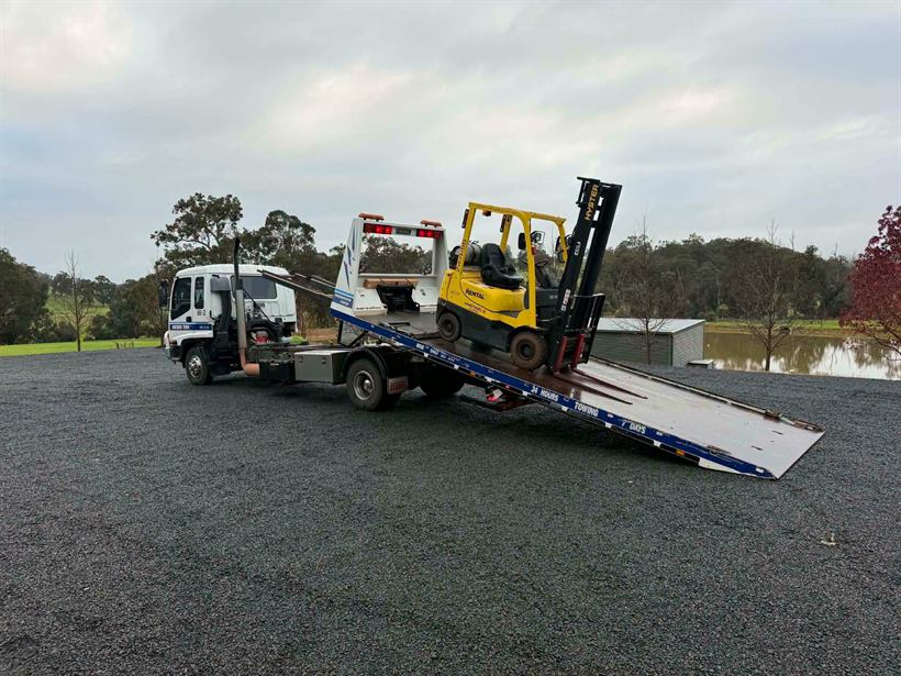 Forklift being loaded up the tilt tray ramp
