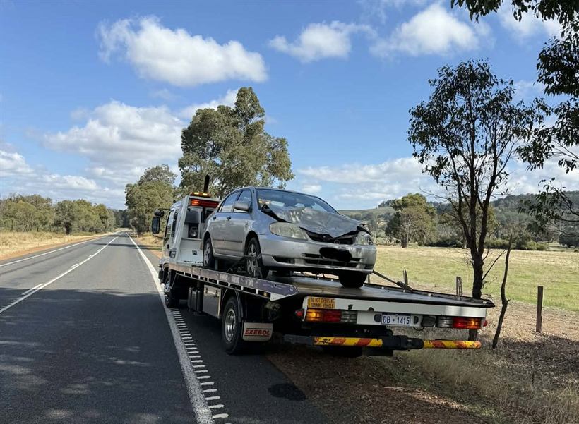 Damaged hatchback loaded on the tray on a country road