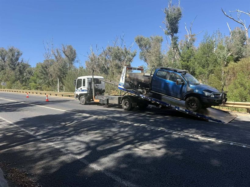 Crashed blue car being recovered from the roadside