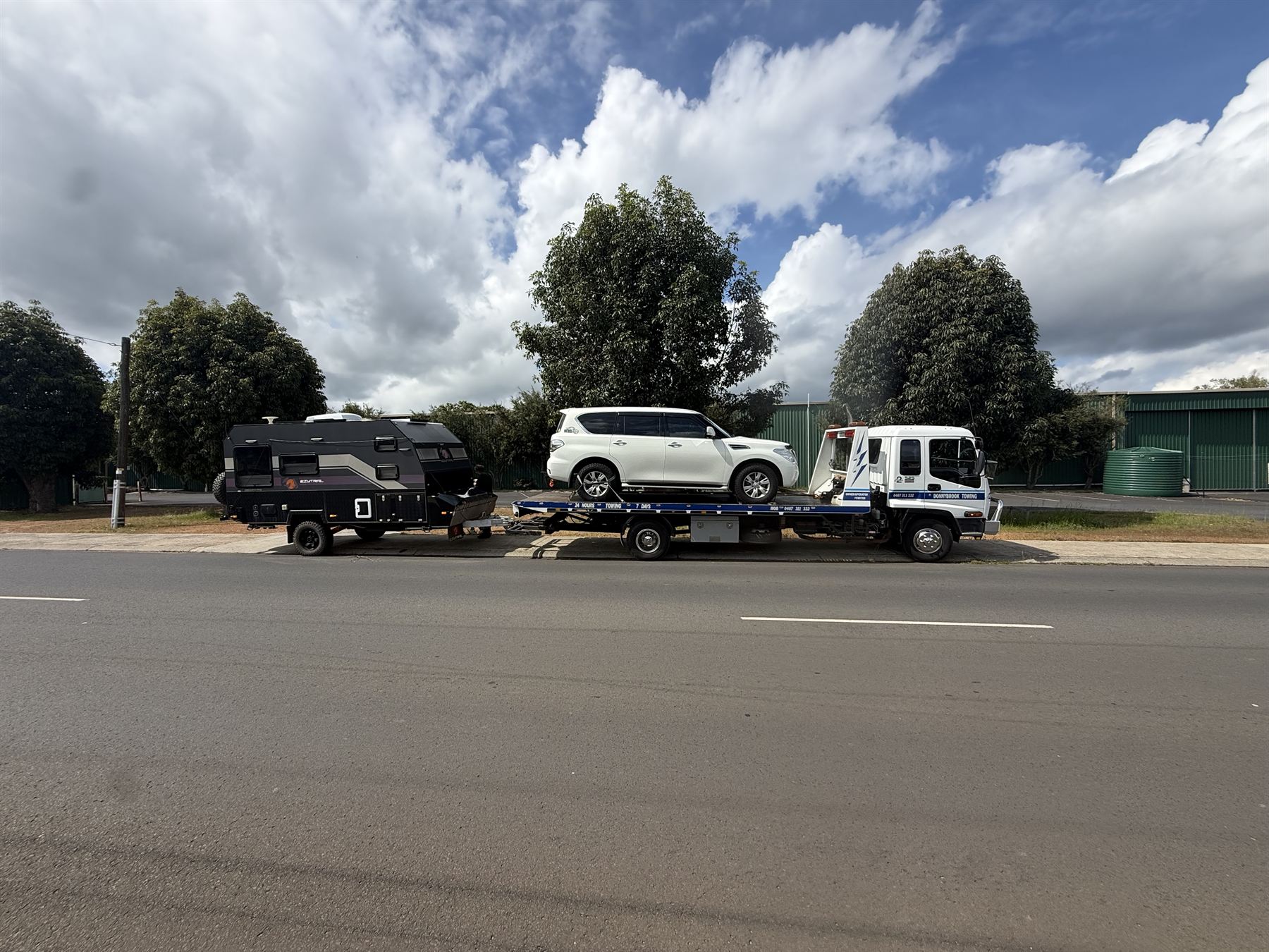 Nissan Patrol on the tilt tray with its caravan hitched behind